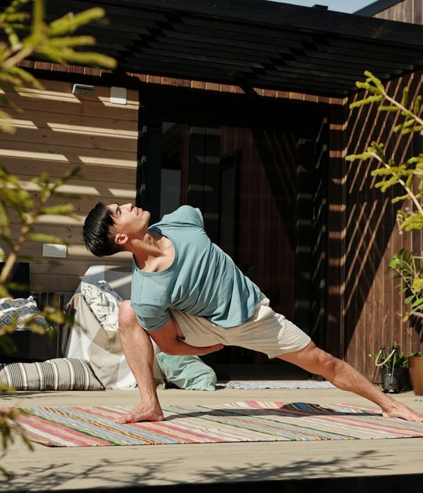 Man stretching in a bright room, showing flexibility and calm.